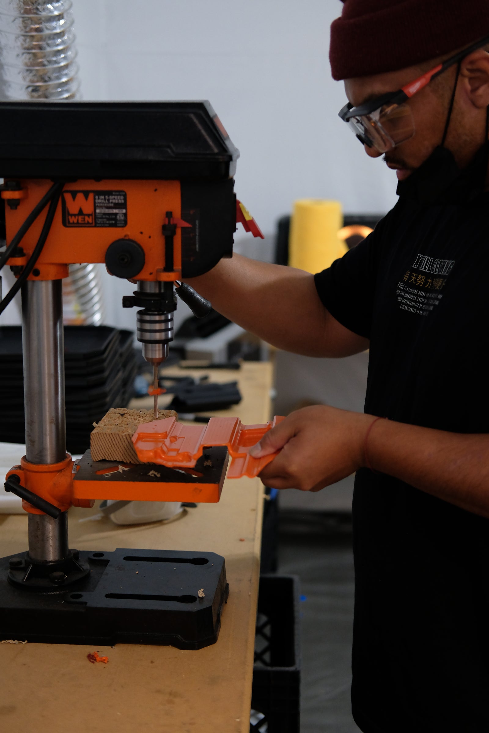 TUKD maker drilling rivet holes in a Kydex holster blank on the drill press at the Las Vegas workshop