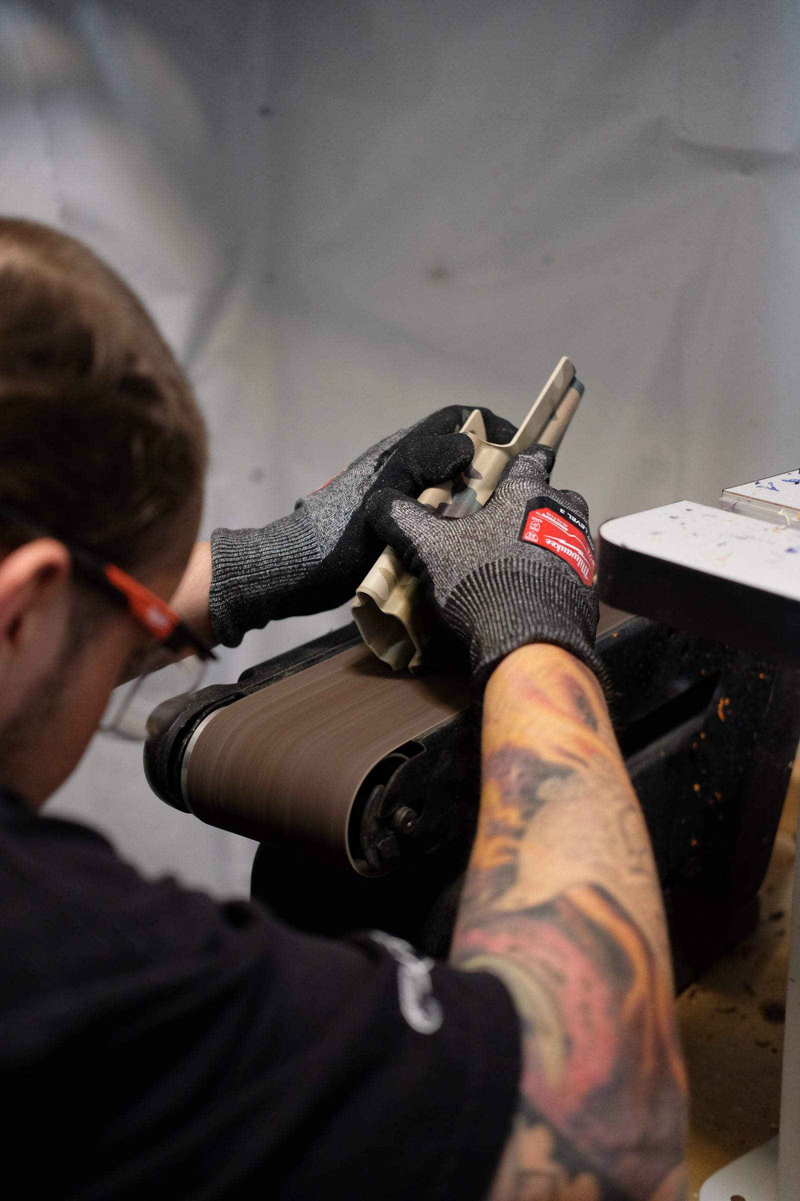 Craftsman hand-finishing a Kydex holster shell at the TUKD workshop in Las Vegas